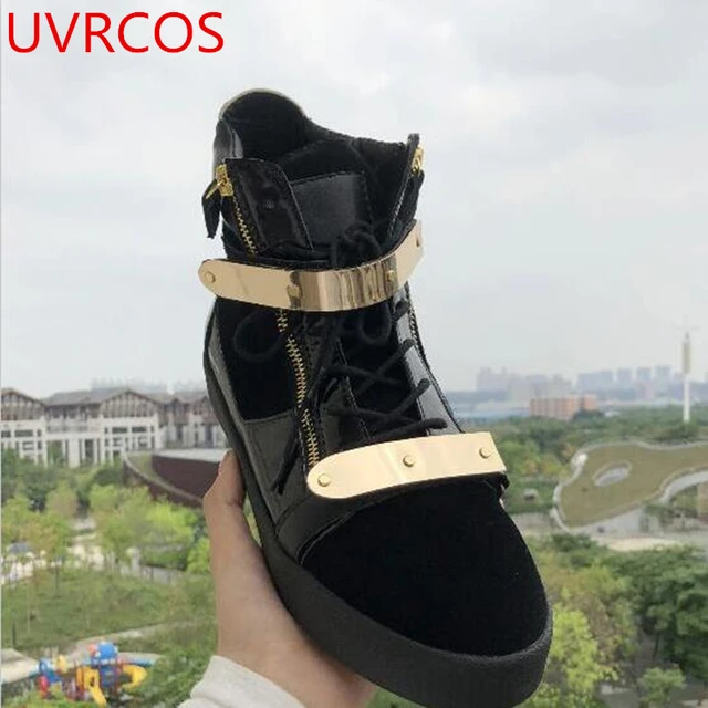 Man with black leather Louis Vuitton boots with golden logo before