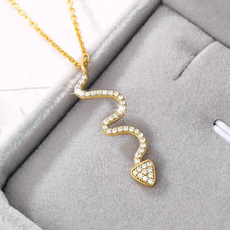 The Snake Pendant, a gold, snake-shaped piece encrusted with small diamonds and elegantly displayed in a gray jewelry box, epitomizes stylish jewelry and makes for a standout addition to women's fashion accessories.