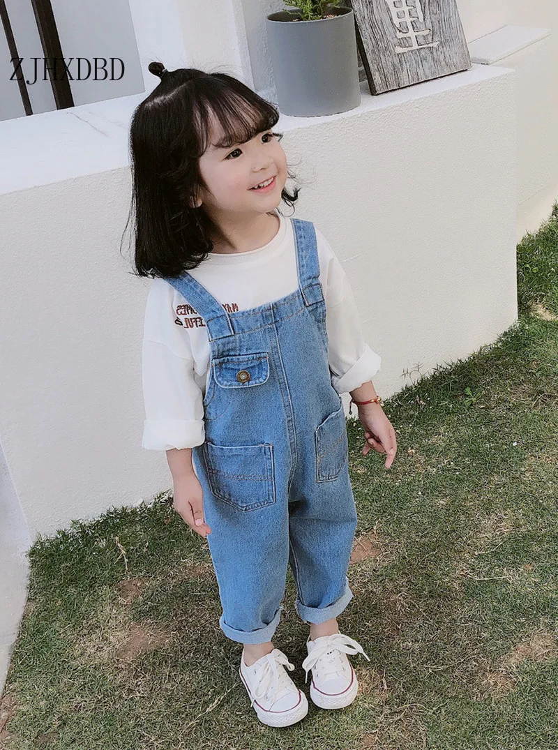 baby girl in overalls