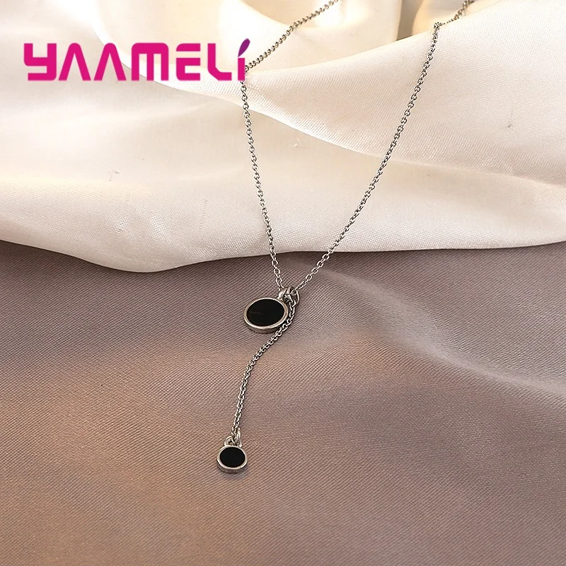 Collar con dije doble círculo negro y plata de ley con dos dijes circulares negros colgantes en una delicada cadena con acabado plateado.