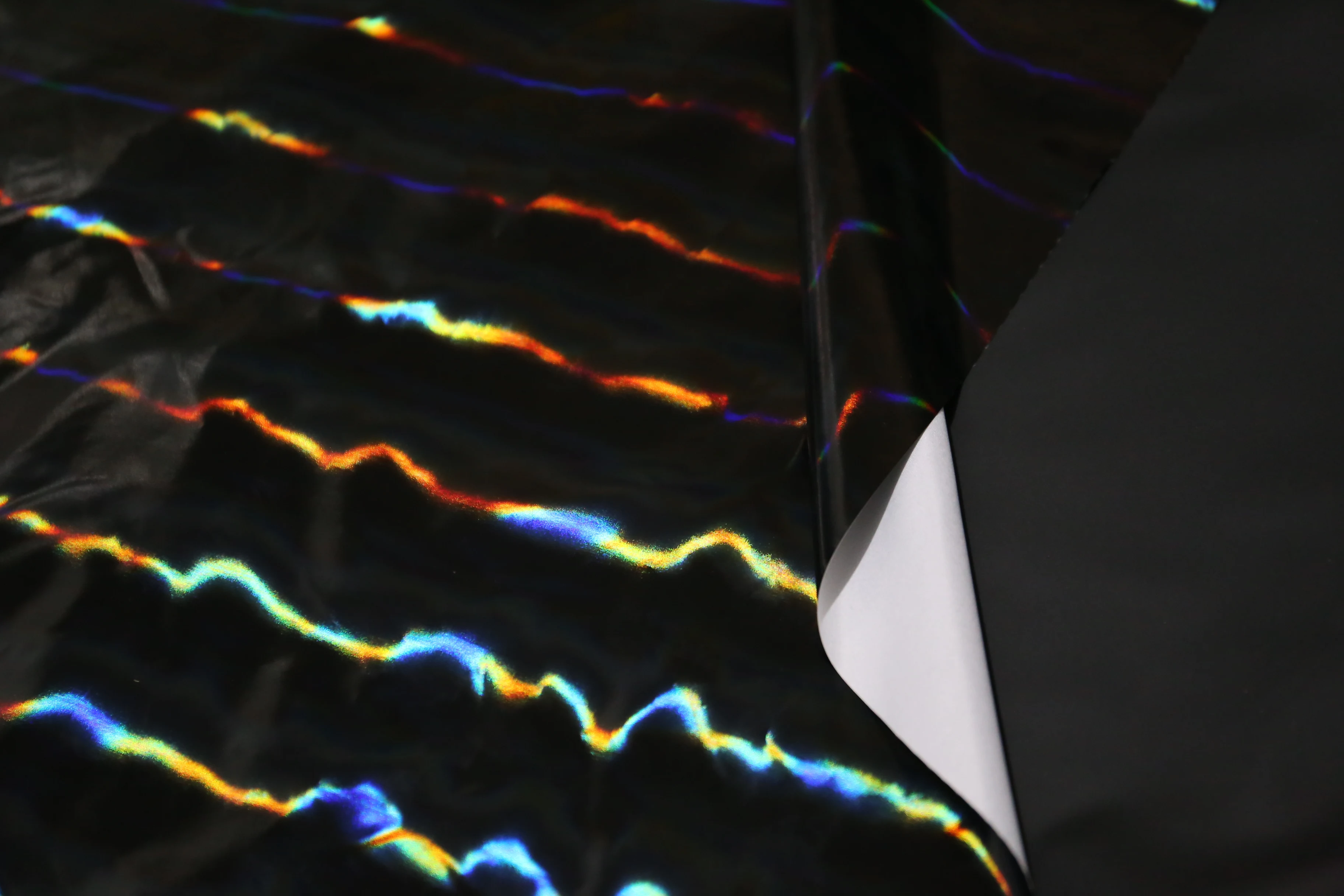 Яркая яркая черная радужная пленка из искусственной кожи зеркальная