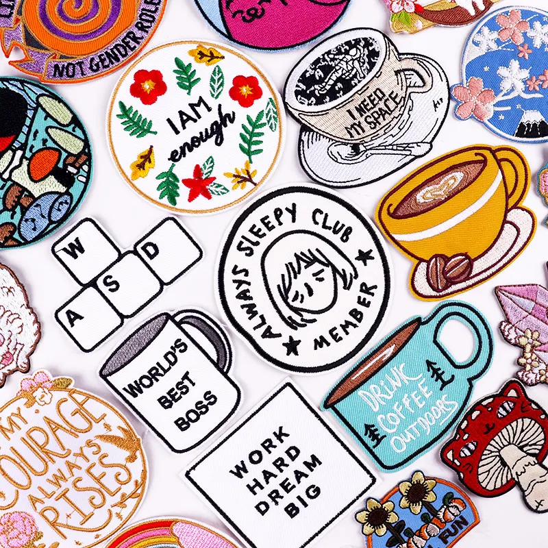 Iron-on embroidered patches with coffee cups, quotes like “World’s Best Boss,” and cozy sleepy club designs