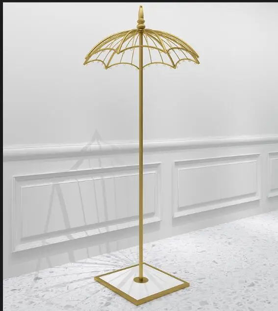 Clothes shop window props are hanging display rack gold creative umbrella  hat stand on the floor