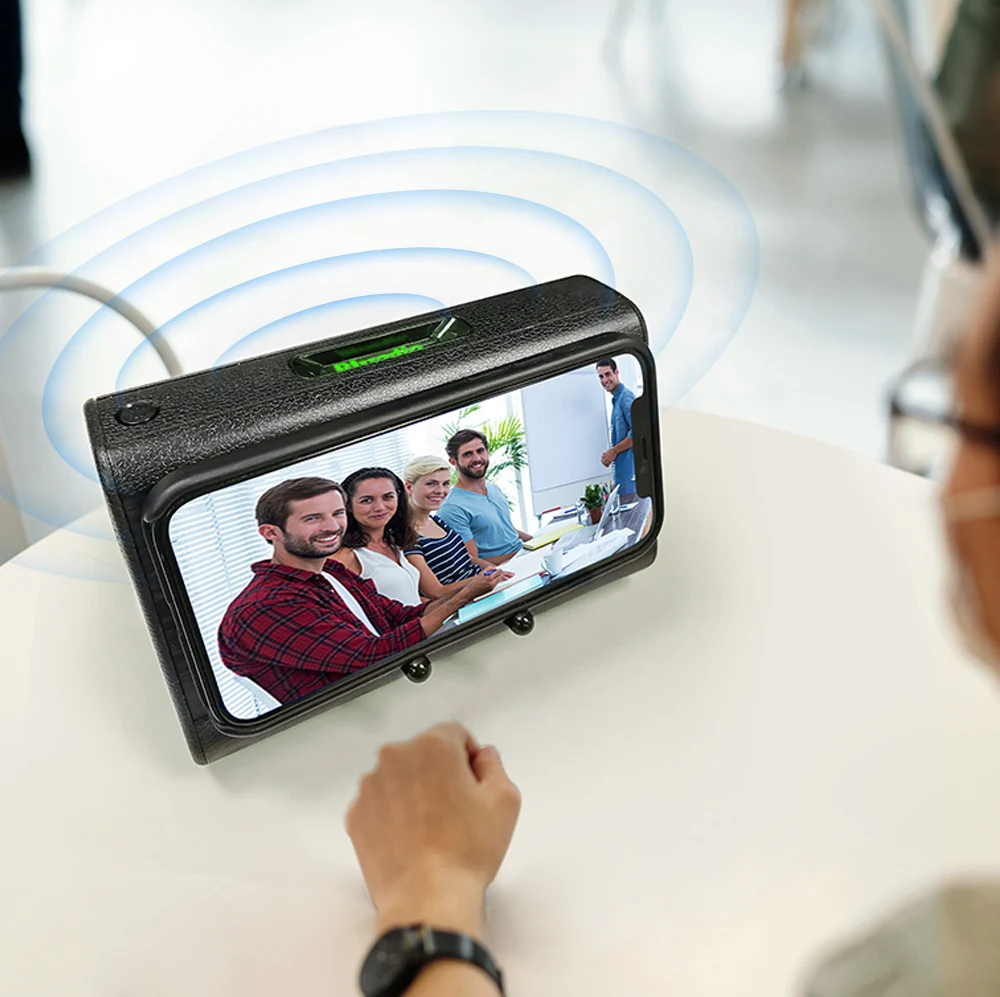 A person uses a Portable Phone Speaker to watch a group of four people on their smartphone screen through a magnifying device, with blue lines indicating wireless connection transmission above the speaker's compact design.
