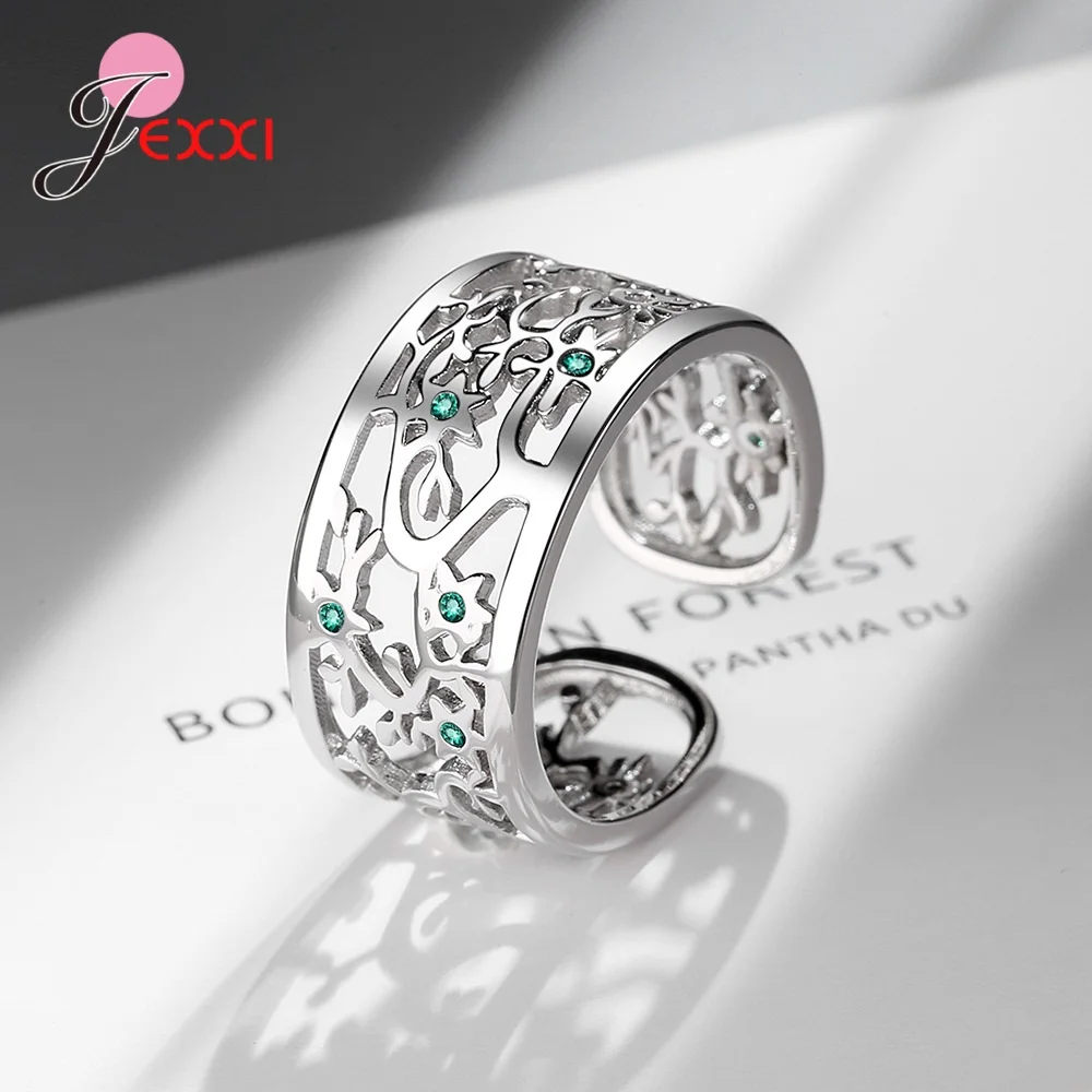 Anneau ouvert arbre de vie en argent sterling avec des pierres de zircon vert et des détails filigranés complexes.