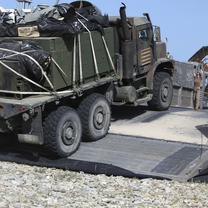A Medium Tactical Vehicle Replenishment is loaded onto a Landing Craft Air Cushion Poster Print (34 x 22) | Дом и сад