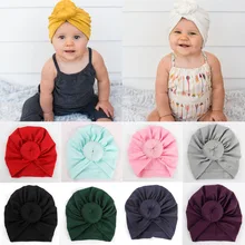 Новая милая мягкая хлопковая шапочка унисекс с бантиком для новорожденных и маленьких мальчиков и девочек, теплая шапка, однотонные мягкие одноцветные шапки, 1 шт