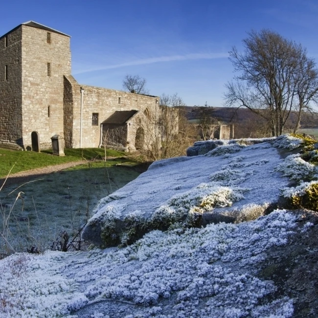 Церковь и кладбище с морозом на траве каменной стене Eglingham Northumberland Англия плакат