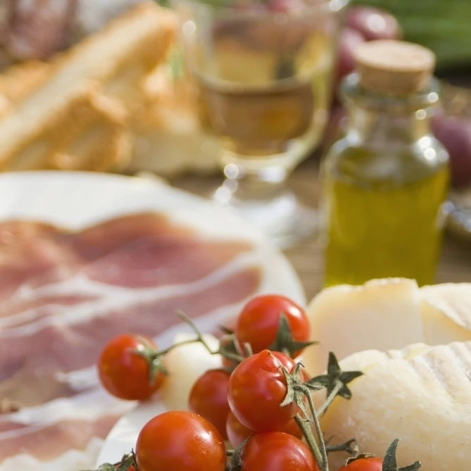 Prosciutto ветчина сыр помидоры белое вино и другие ингредиенты для пикника Тоскана