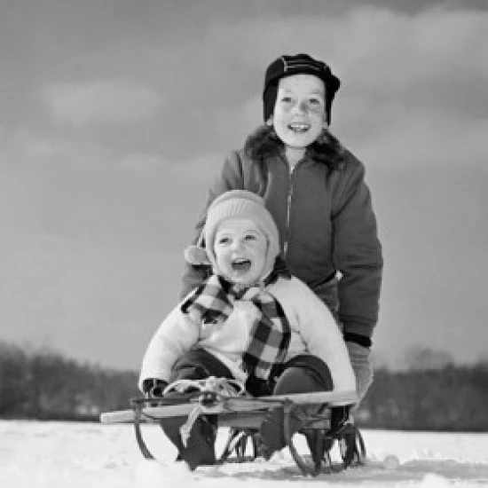 Boy pushing his brother on a sled Poster Print (18 x 24)