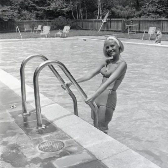 Attractive young woman standing in swimming pool Poster Print (24 x 36)