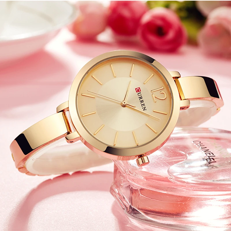 An Ultra Thin Romantic Clock Women's Watch delicately resting on top of a glass, adding a touch of romantic elegance to any woman's wrist.