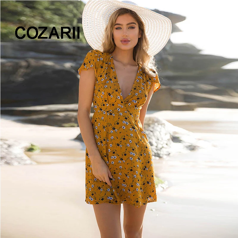 COZARII الأصفر التفاف الشاطئ اللباس البسيطة مثير V الرقبة المرأة الصيف الشاطئ اللباس قصيرة الأكمام الأزهار طباعة أنيقة بوهو القمم bigsizeXXL