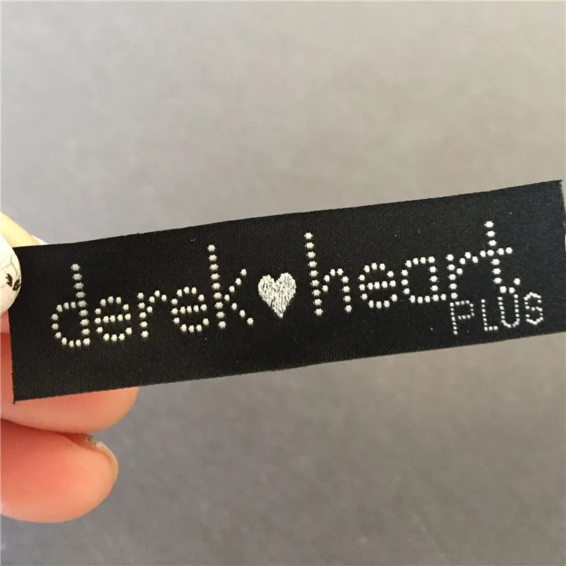 

Customized 1.7*6.3cm 50D Exquisite Material with Silver Bright Shine Heart Logo High -Density Garment Woven Label