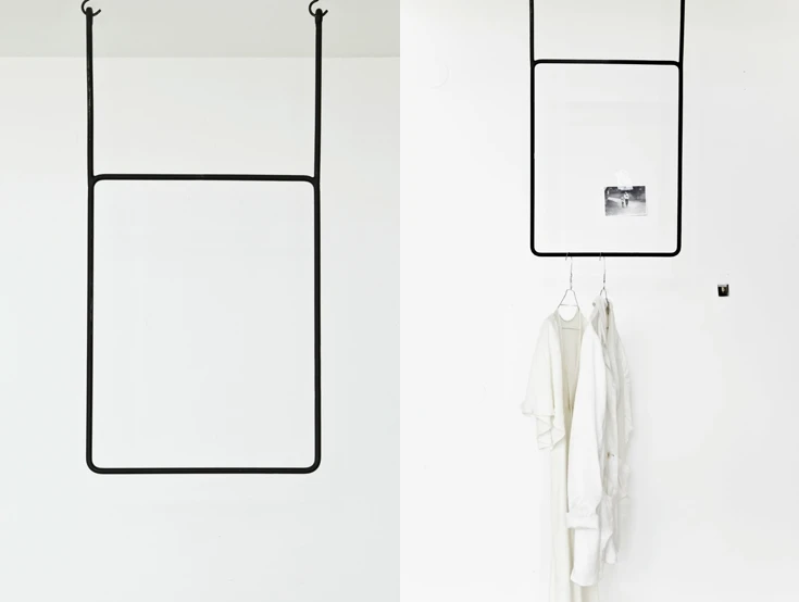 Black and white clothes hanging gantry. Clothing display shelf, display stand, ceiling hangs clothes hangers