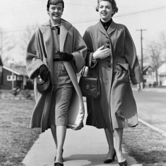 Two young women walking on a walkway and smiling Poster Print (18 x 24)