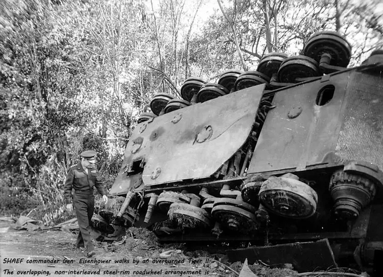 SHAEF-commander-Gen.-Eisenhower-walks-by-an-overturned-Tiger-II.-The-overlapping,-non-interleaved-steel-rim-roadwheel-arrangement-is-visible.