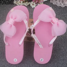 Venta caliente del color del caramelo de las mujeres de moda zapatillas de playa de vacaciones de verano de las señoras inferiores suaves antideslizantes de fondo plano flip flop con bowtie