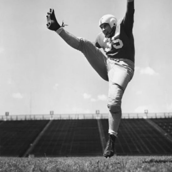 Low angle view of a football player practicing kicking in a stadium Poster Print (18 x 24)