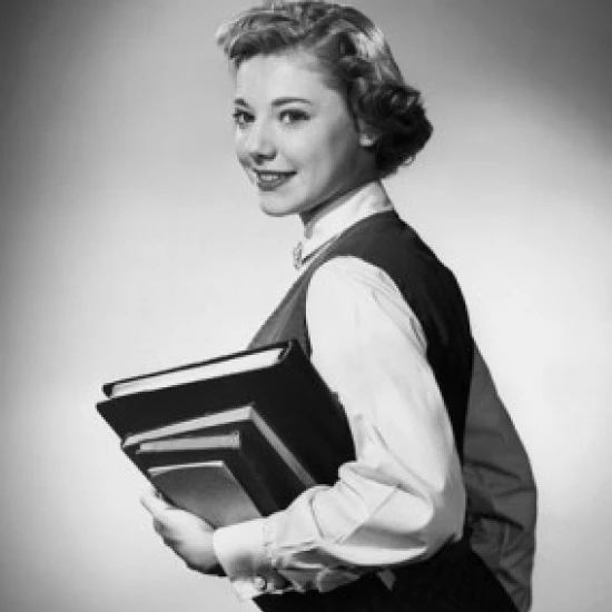 Teenage girl carrying stack of books and smiling Poster Print (24 x 36)