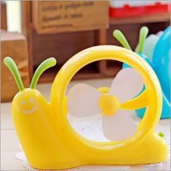 

Mini Snail with Yellow Fan Lying on The Ground Household Daily Familiar Article of Everyday Use Products Family Air Cooling Fan