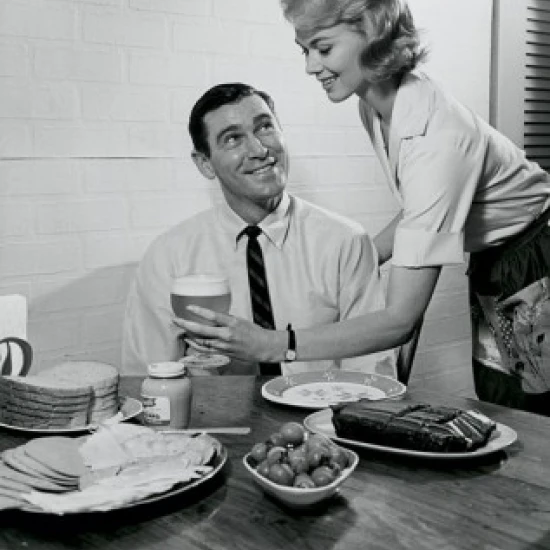 Side profile of a young woman serving food to a young man Poster Print (24 x 36)