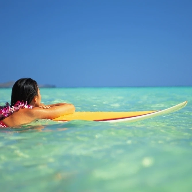Hawaii  Oahu  Lanikai  Woman Resting On Surfboard Looking Out On Clear Teal Water. Poster Print (17 x 11)