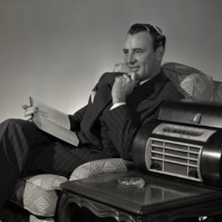 Man with book witting on armchair Poster Print (18 x 24)