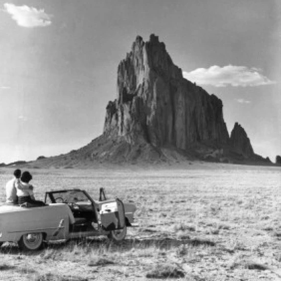 Rear view of a young couple sitting in a convertible car Poster Print (18 x 24)