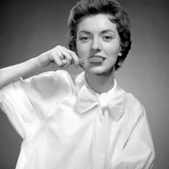 Portrait of woman cleaning teeth Poster Print (24 x 36)