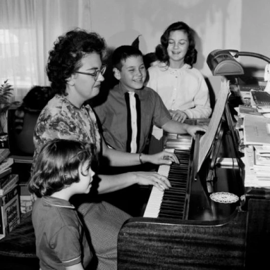 Mother playing piano and children singing Poster Print (18 x 24)