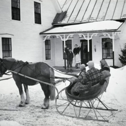 Grandparents waving at family sitting on sled Poster Print (24 x 36)