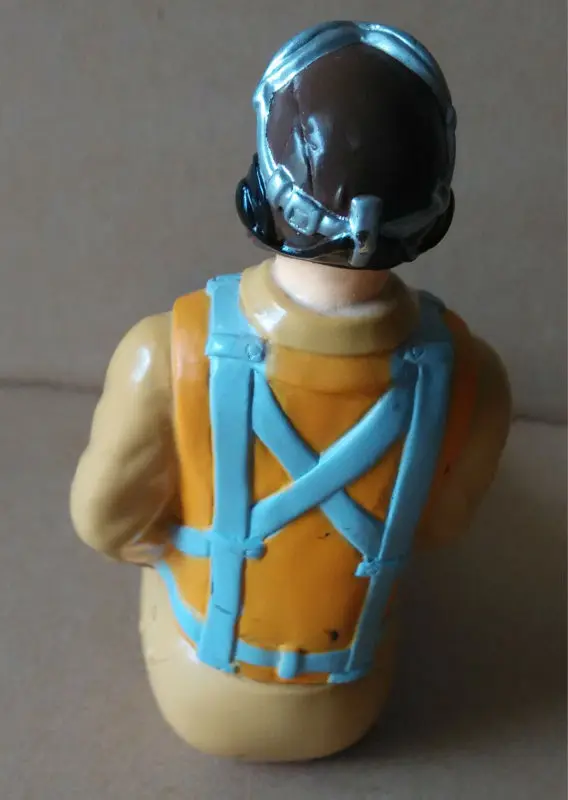 Pilote d'avion RC échelle 1/6 en tenue de vol, casque et lunettes, prêt à piloter.