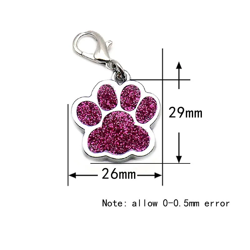 A glittery pink paw charm with a clasp is shown with dimensions: 29mm in height and 26mm in width. Note mentions a possible 0-0.5mm error in measurements. This chic accessory, The Stuff Box's High Quality Engravable Pendants for Dogs and Cats 100Pcs, pairs perfectly with our personalized paw ID tags, adding both style and function to your pet's look.