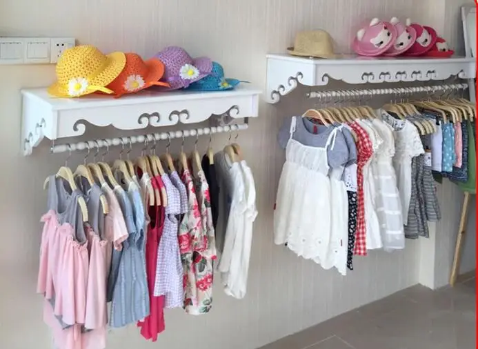 High-end women's clothing shelves. White wall-mounted hangers. Clothing store hangers.005