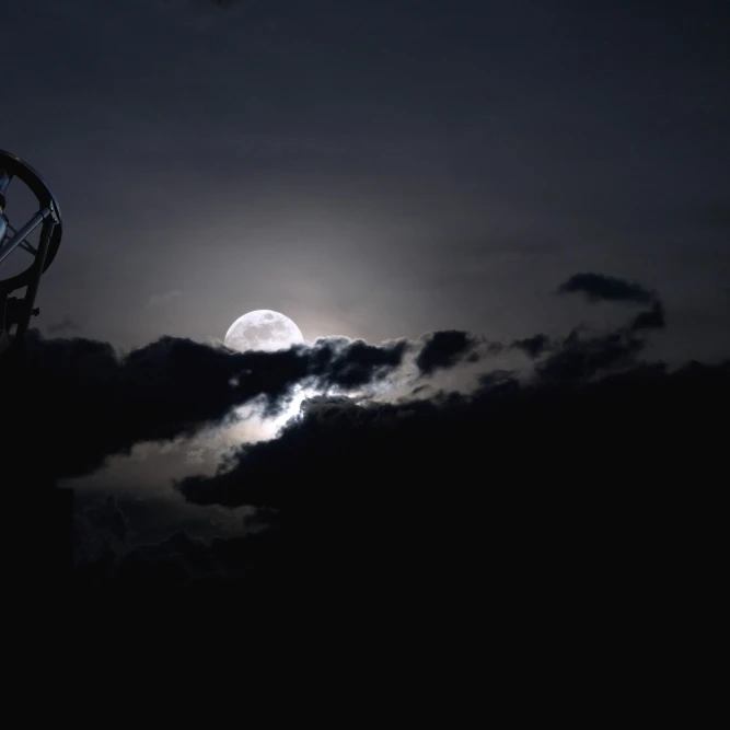 Telescope pointed out to the night sky with moon and clouds Poster Print (34 x 23)