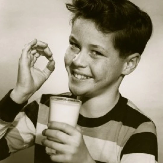 Portrait of a pleased boy holding a glass of milk Poster Print (18 x 24)