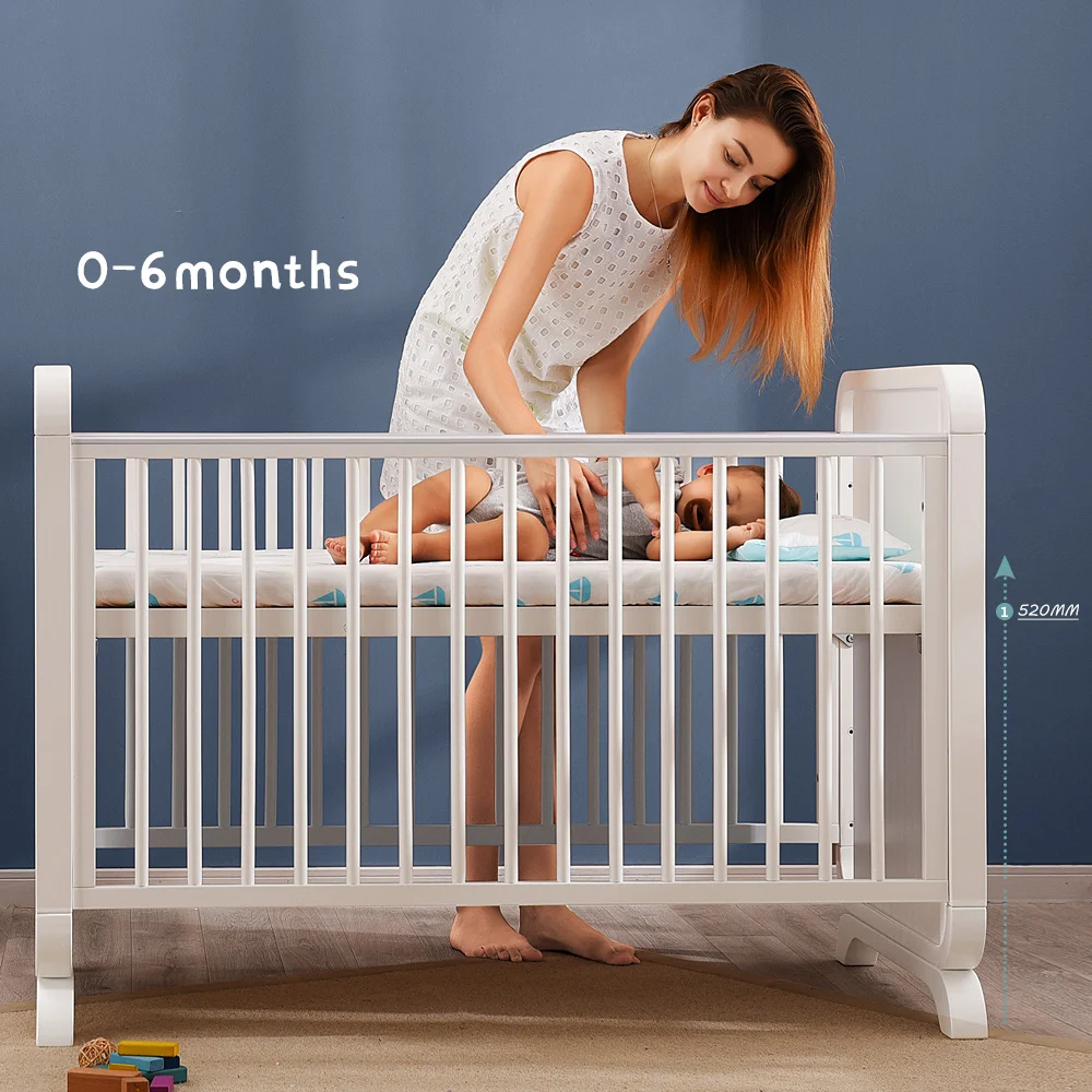 white wooden baby cot