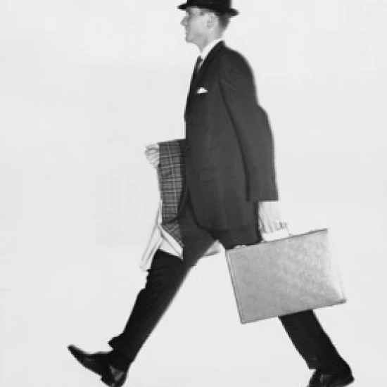 Side profile of a businessman carrying a briefcase and an overcoat Poster Print (18 x 24)