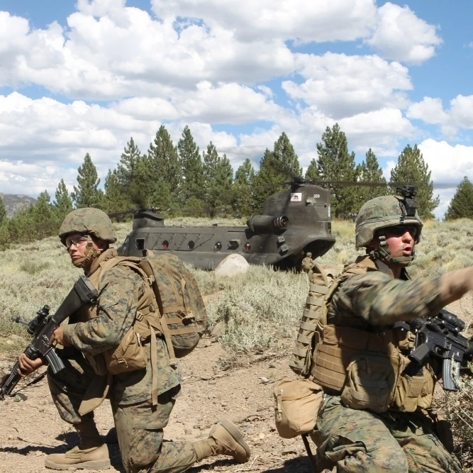Soldier directs his Marines towards a CH-47 Chinook during an extraction Poster Print (17 x 11)