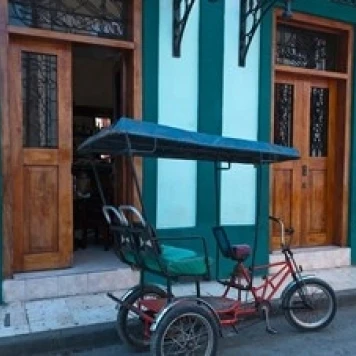 Cuba  Camaquey  bike carriage and buildings Poster Print by Bill Bachmann (29 x 19)