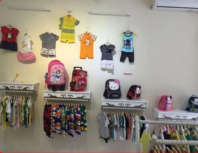 High-end women's clothing shelves. White wall-mounted hangers. Clothing store hangers.005