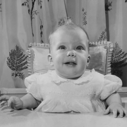 Baby girl sitting in a high chair Poster Print (24 x 36)