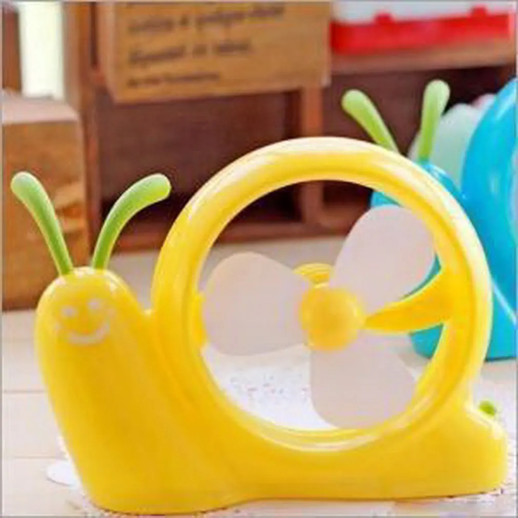 

Mini snail with yellow fan lying on the ground household daily products family familiar article of everyday use