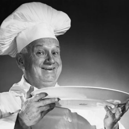 Portrait of a male chef holding a plate and smiling Poster Print (18 x 24)