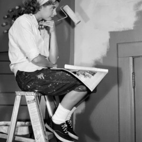 Woman sitting on ladder with paint roller Poster Print (24 x 36)
