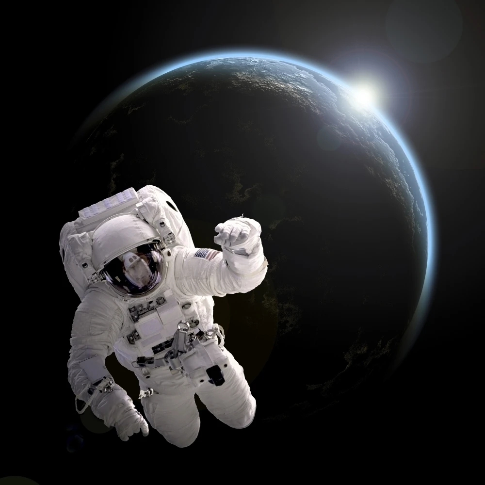 Astronaut floating in space as the sun rises on an Earth like planet