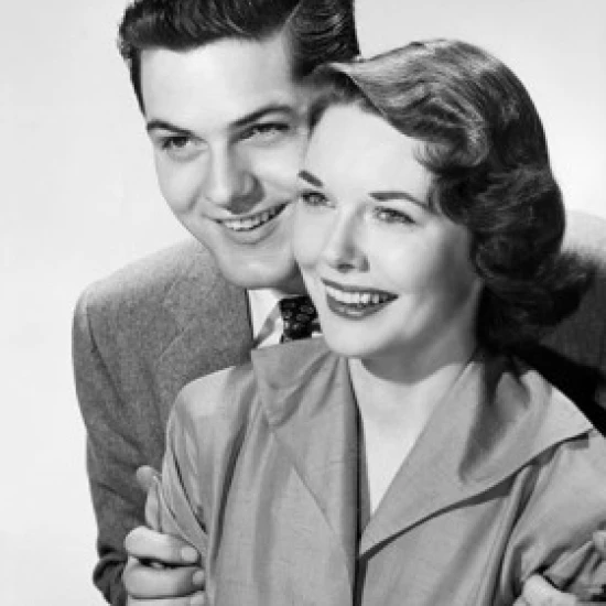 Mid adult man embracing a mid adult woman from behind Poster Print (18 x 24)