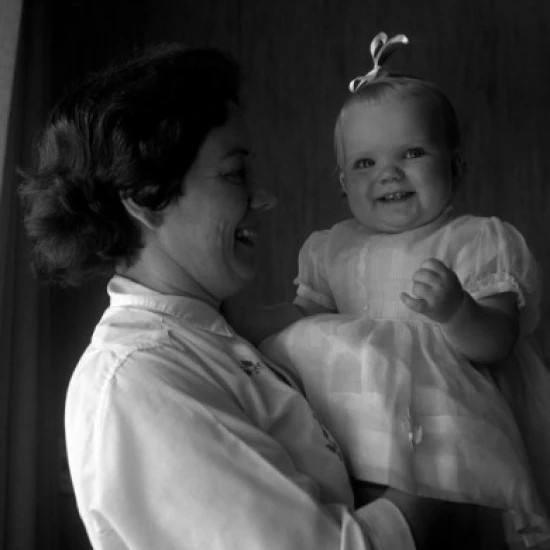 Mature woman holding baby girl Poster Print (18 x 24)