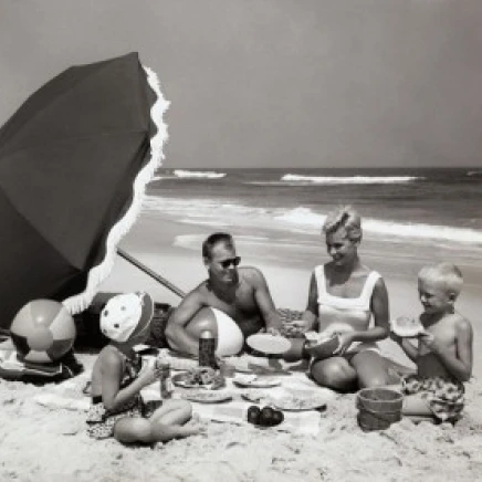 Parents and their two children having a picnic on the beach Poster Print (24 x 36)